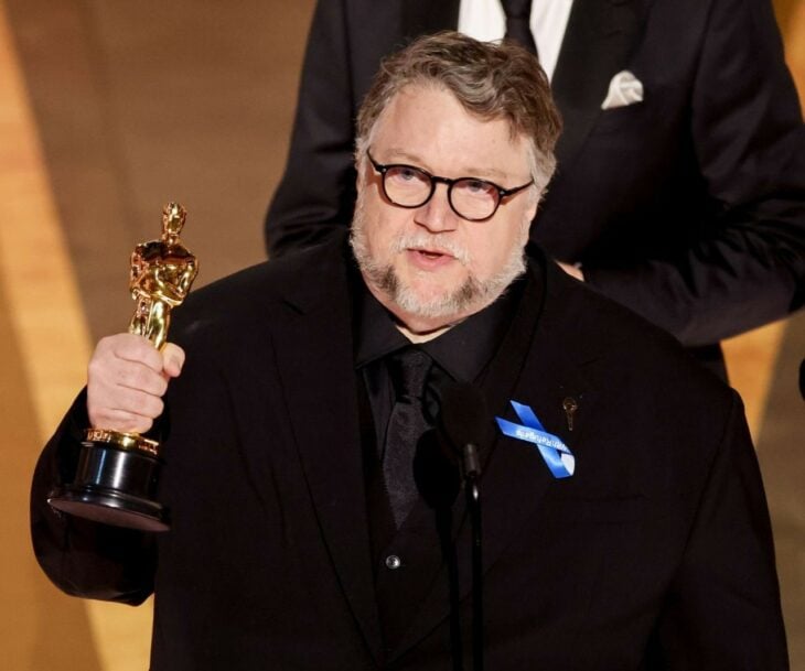 Guillermo del Toro carrying his Oscar for Best Animated Feature Film during his speech