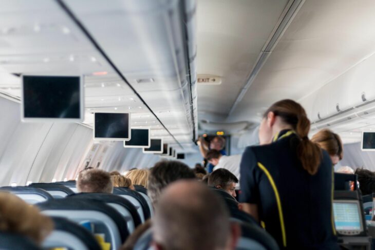 imagen de una azafata atendiendo a unos pasajeros en un vuelo 
