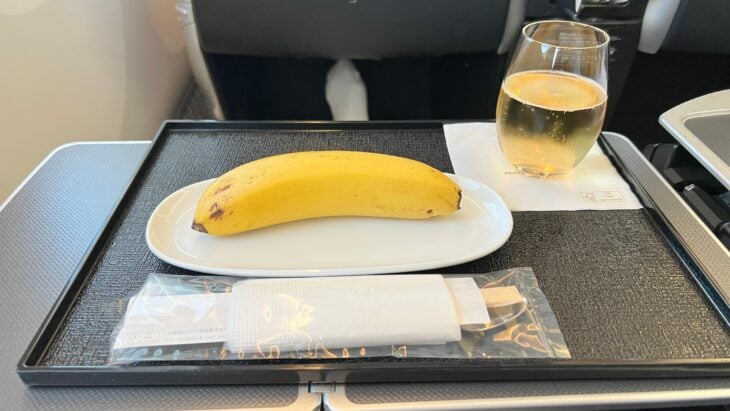 plátano sobre un plato con cubiertos en un vuelo de Indonesia a Japón 