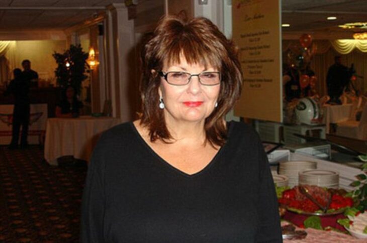 photograph of a woman dressed in black posing at a party