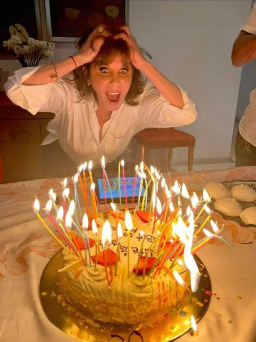 Rebecca Jones festeja divertida su cumpleaños número 65 con un pastel lleno de velas encendidas