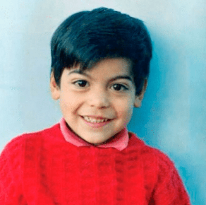 Carlos Rivera de niño esta sonriendo a la cámara