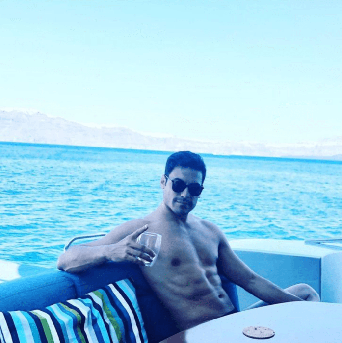 Carlos rivera photographed on a yacht at sea carries a glass that has a drink in his hand