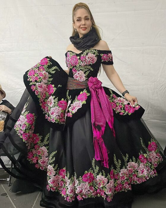 Fotografía de Heidy Infante, nieta de Pedro Infante usando un vestido negro con detalles en flores color rosa 