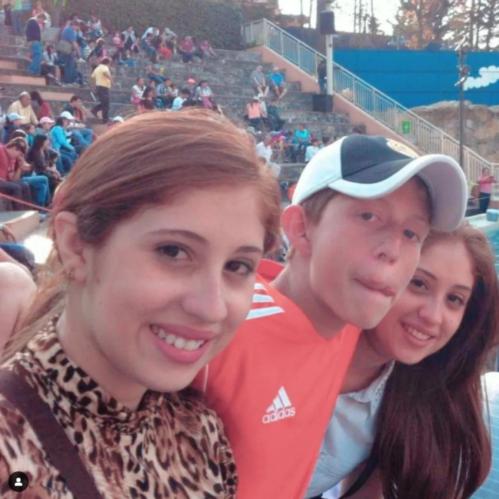 El actor Octavio Ocaña en compañía de sus hermanas están dentro de un estadio sentados en las gradas rodeados de gente