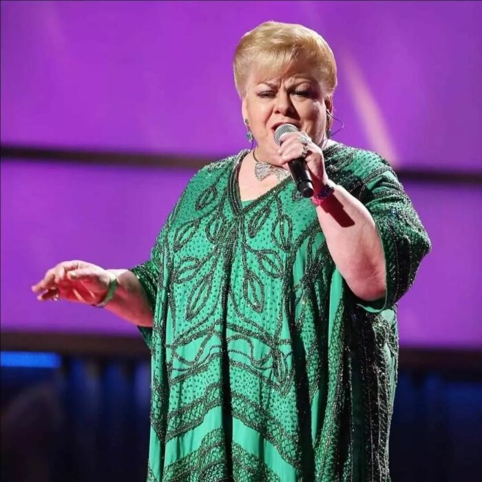 Photograph of the singer Paquita la del Barrio singing on stage in a green dress 