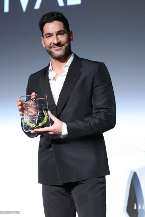 Tom Ellis posando con un premio de Filming Italy en Los Ángeles 