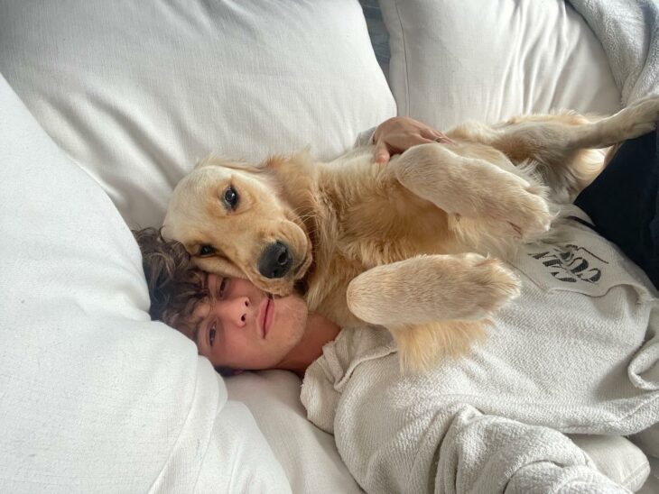 Shawn Mendes posando en su cama con un perro 