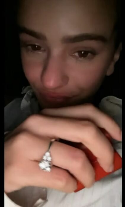 Fotografía de la cantante Rosalía mostrando su anillo de compromiso en el video musical de Beso junto a su novio Rauw Alejandro 