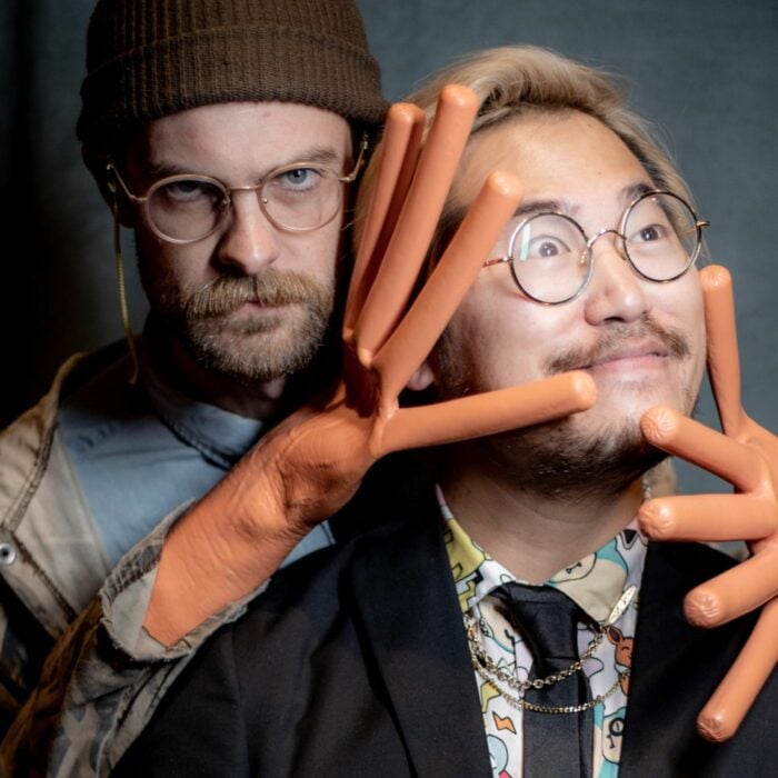 Daniel Kwan y Daniel Scheinert posando con guantes de dedos de salchica