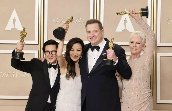 Ke Huy Quan, Michelle Yeoh, Brendan Fraser and Jamie Lee Curtis holding up their statuettes at the 2023 Oscars