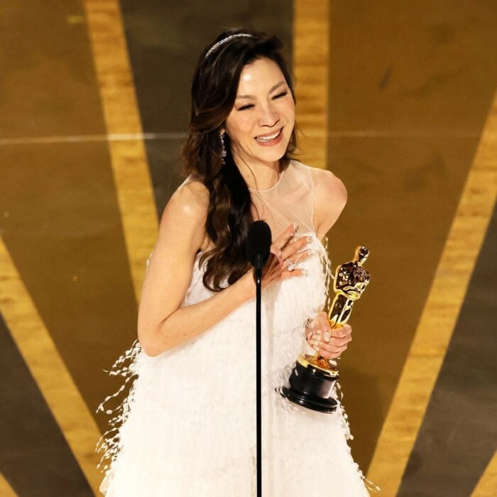 Michelle Yeoh carrying her Oscar for Best Actress during her speech