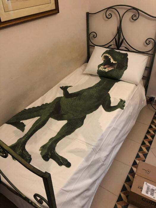 cama adornada con un dibujo de un dinosaurio de T-Rex