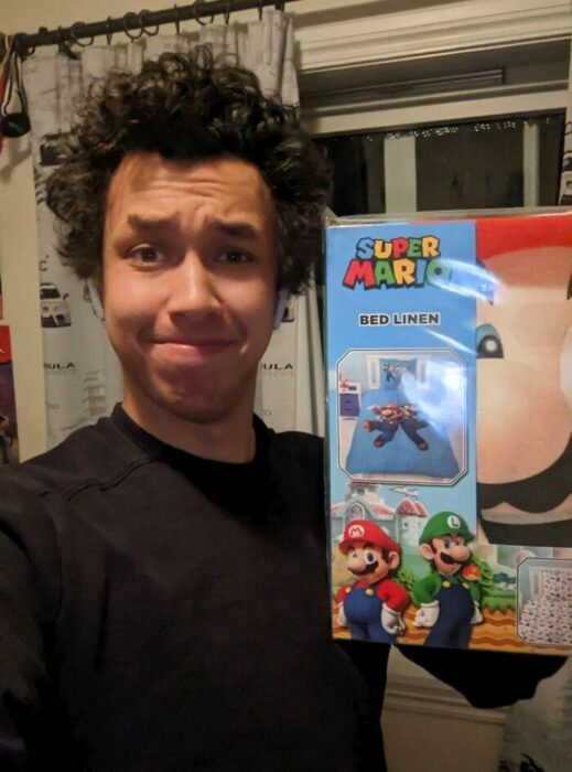 selfie de un chico presumiendo sus sábanas de Mario Bros 