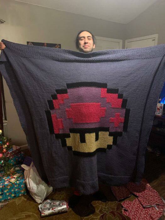 imagen de un chico mostrando una manta con la imagen de Toad de Mario Bros 