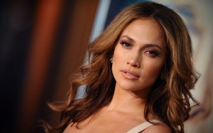 Jennifer Lopez posa sexy con el cabello peinado en ondas y vestido de tirantes