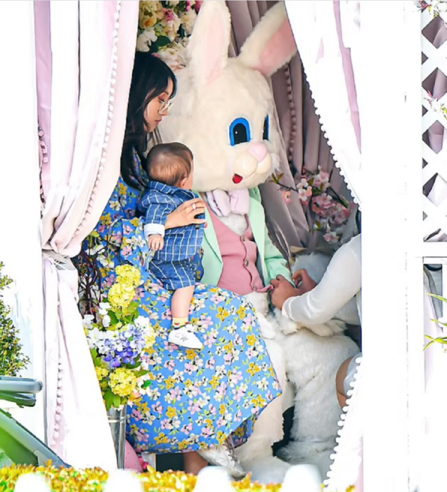 Brenda Song sostiene en sus brazos a su hijo menor mientras se preparan para tomarse fotos con el conejo de Pascua