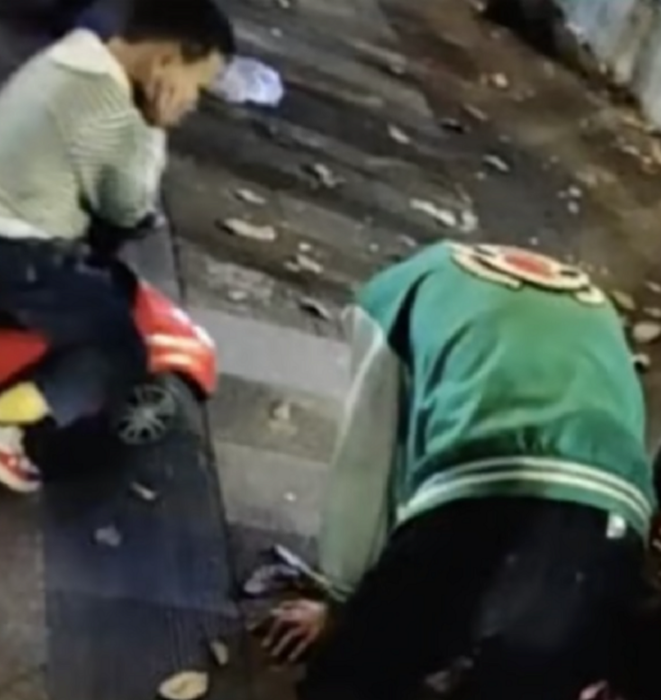 un hombre está arrodillado en el pavimento mientras un niño en su cochecito de juguete lo mira incrédulo