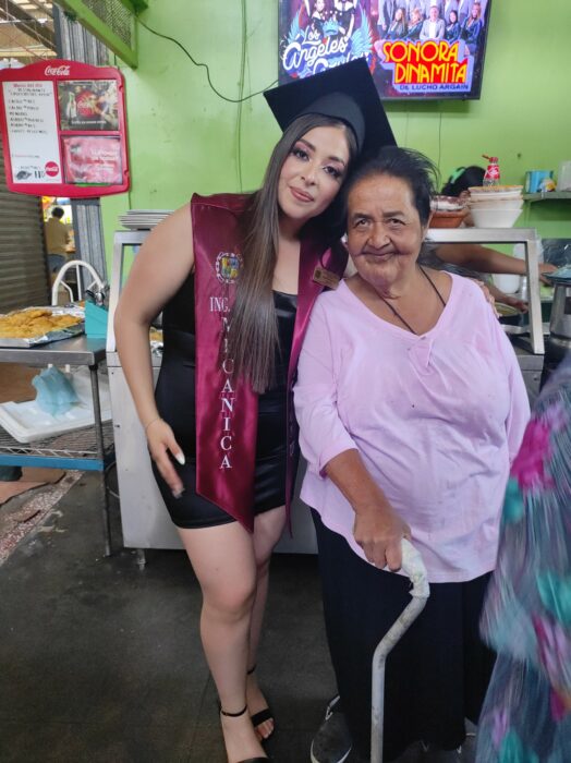 Fotografía de una chica graduada al lado de una mujer en un local en un mercado de Saltillo, Coahuila