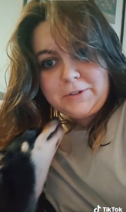 captura de pantalla de una mujer siendo lamida por su cachorro en la cara 