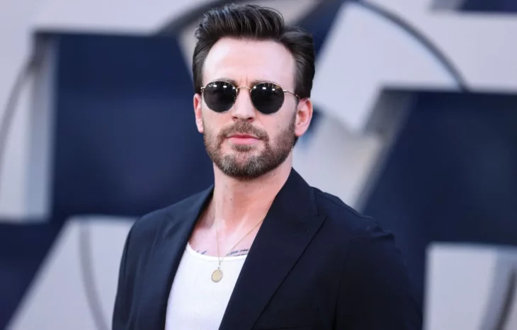 Chris Evans luciendo guapísimo en un evento lleva saco negro y lentes oscuros su barba está muy marcada