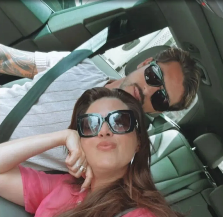 Christian Estrada y Alicia Machado juntos en el interior de un vehículo ambos lucen lentes de sol