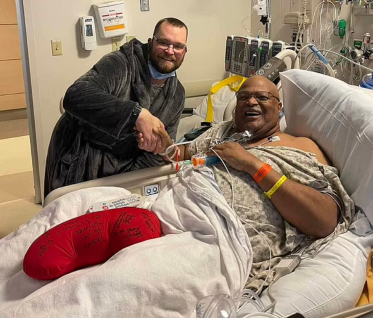 un hombre caucásico saluda en la cama de un hospital a otro hombre afroamericano