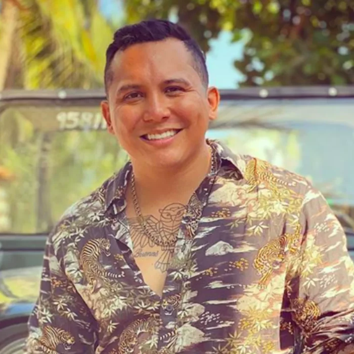 Edwin Luna vocalista de la banda La Trakalosa de Monterrey posa con una camisa bordada y una sonrisa