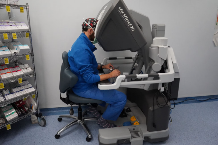 un médico dirigiendo una operación de trasplante de pulmón en el hospital español Vall d’Hebron a través de una computadora con palancas que dirigen brazos robóticos