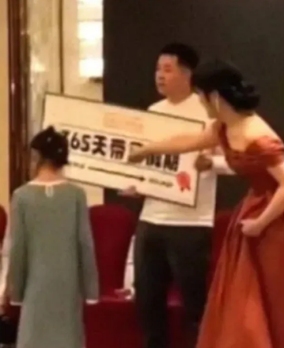 una familia de China festeja junto a un empleado el premio que se ganó 365 días de vacaciones pagadas su esposa luce un vestido largo de fiesta y una niña con vestido está frente a ellos