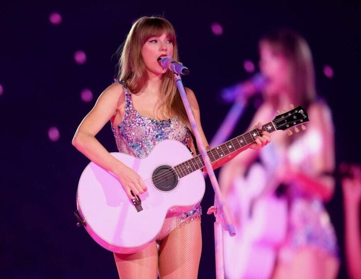 Taylor Swift tocando la guitarra en el escenario en uno de sus conciertos 