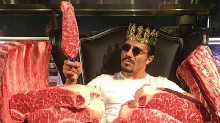 el chef Salt Bae rodeado de grandes trozos de carne con una corona de rey en la cabeza