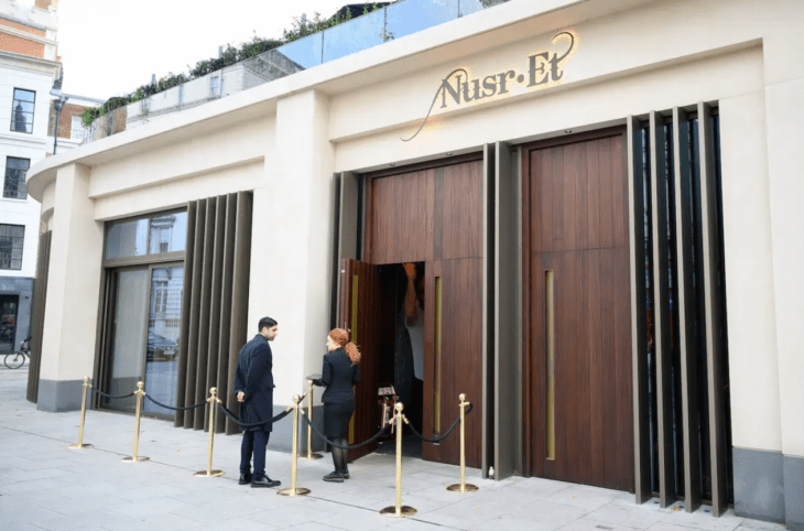 imagen exterior de uno de los restaurantes de Salt Bae el Nusr-Et fachada en color crema con grandes puertas de madera 