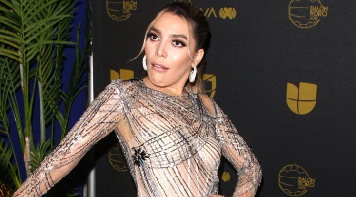 Frida Sofía fotografiada en un evento público hace un gesto de desagrado luce un vestido de noche y el cabello recogido 