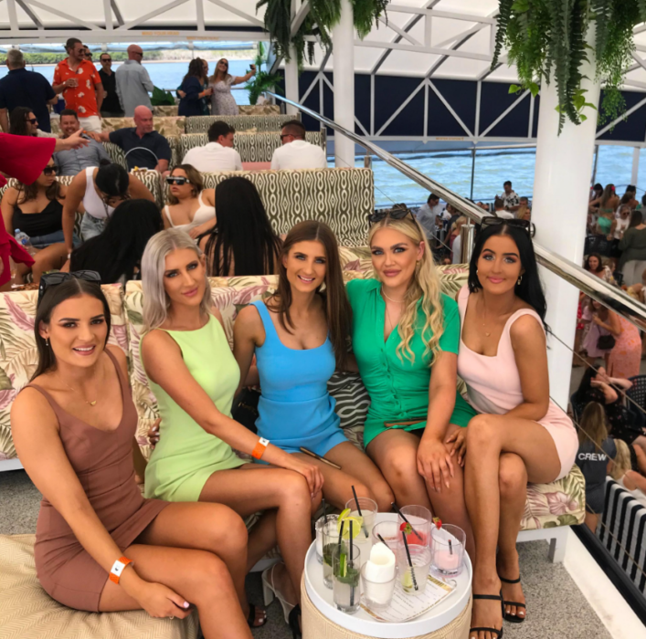 un grupo de amigas posan en una foto mientras están en un restaurante tomando bebidas