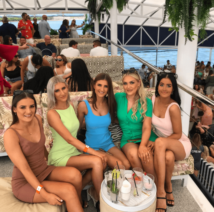 un grupo de amigas posan en una foto mientras están en un restaurante tomando bebidas