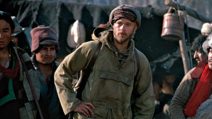 Brad Pitt en una escena de la película Siete años en el Tibet viste con ropa desgastada y está rodeado de tibetanos
