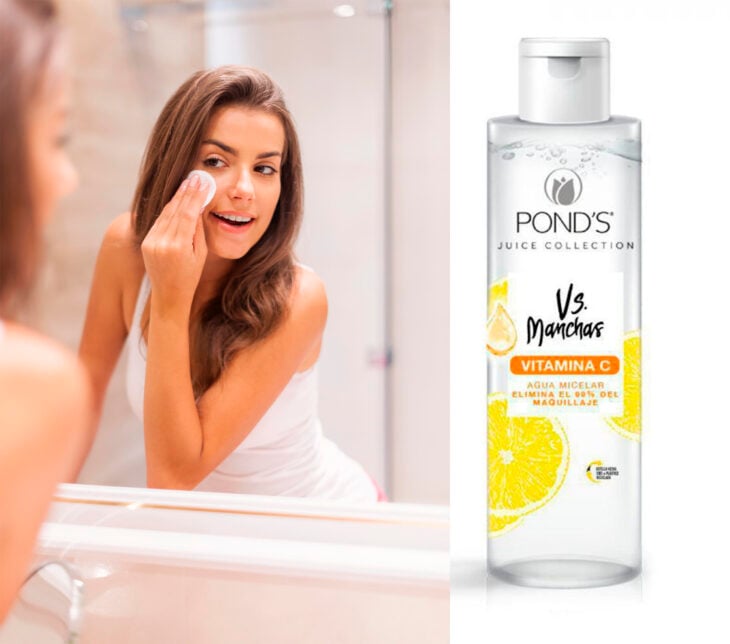 mujer en el espejo limpiando su cara con agua micellar de Pond's vs Manchas 