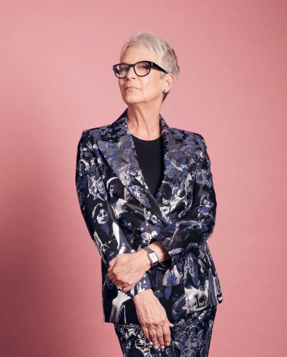 Jamie Lee Curtis posando sobre un fondo en color rosa 