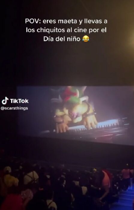 captura de pantalla de una sala de cine llena de niños viendo la película de Mario Bros 
