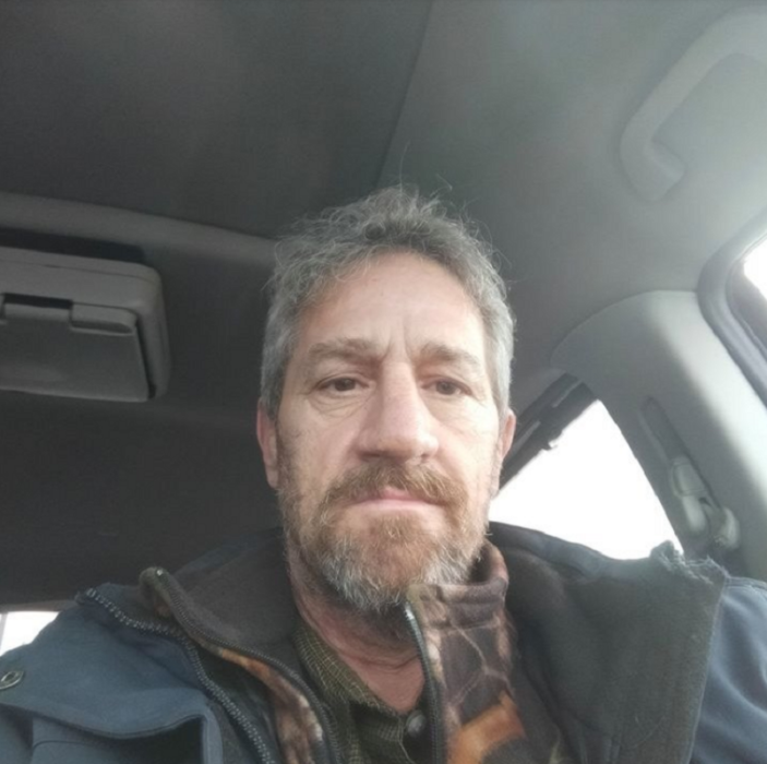 un adulto mayor se toma una selfie en su auto tiene una expresión de preocupación en su rostro