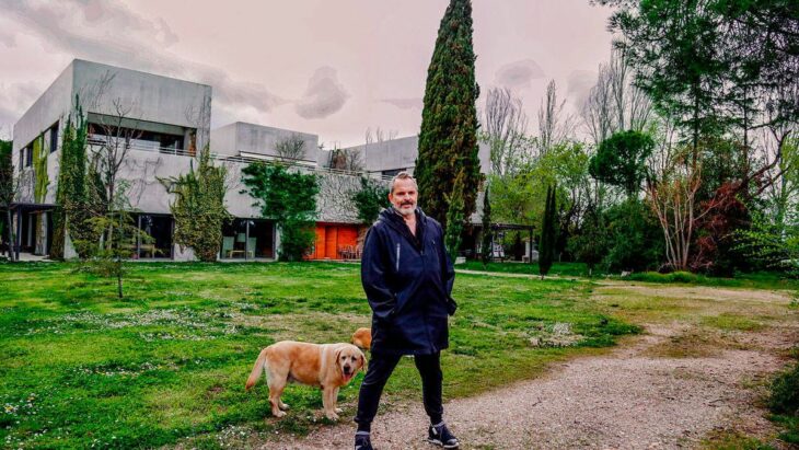 El cantante Miguel Bosé posa junto a su mascota en el exterior de la que era su mansión de Madrid en España