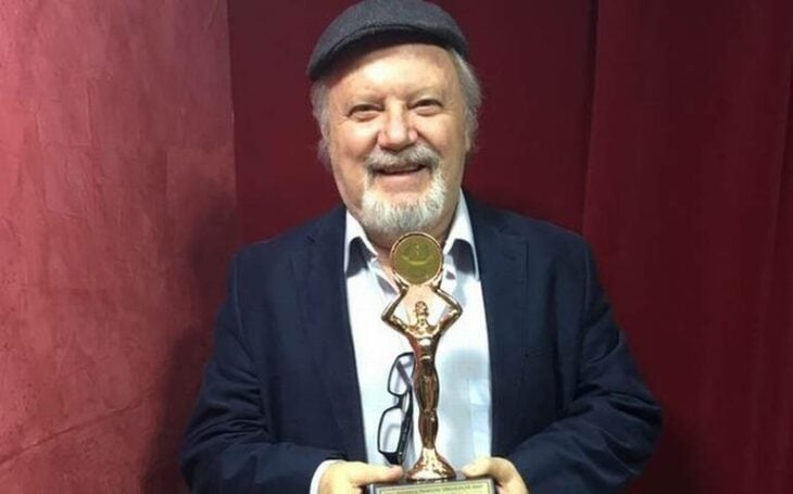 Sergio DeFassio, actor y comediante, sosteniendo un premio