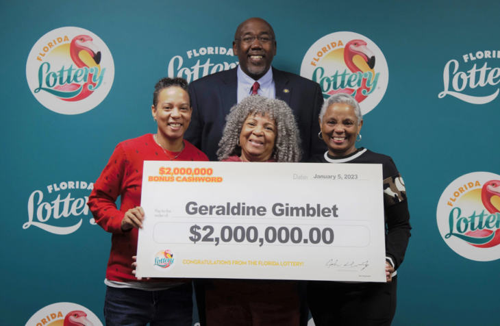 una familia afroamericana recibe de forma simbólica con un cheque gigante el premio que se ganaron de la lotería 