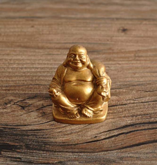 una réplica de Buda en oro puesta sobre una mesa de madera