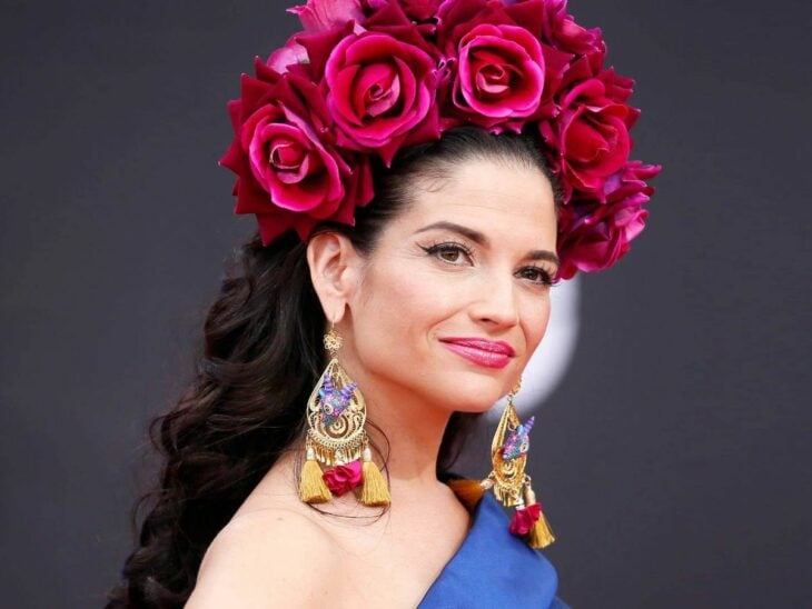 la cantante española Natalia Jiménez posa para la cámara con un enorme tocado de rosas en tono rosa mexicano 