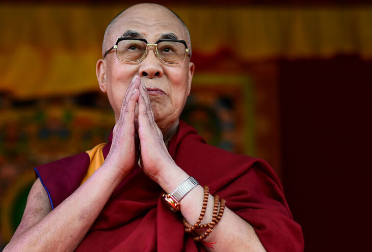El Dalai Lama saluda al público juntando sus manos a la altura de su barbilla