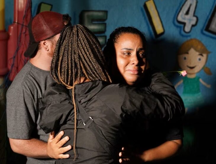 Mujeres abrazándose en guardaría luego de que hombre matara a 4 niños con un hacha en un ataque en Brasil