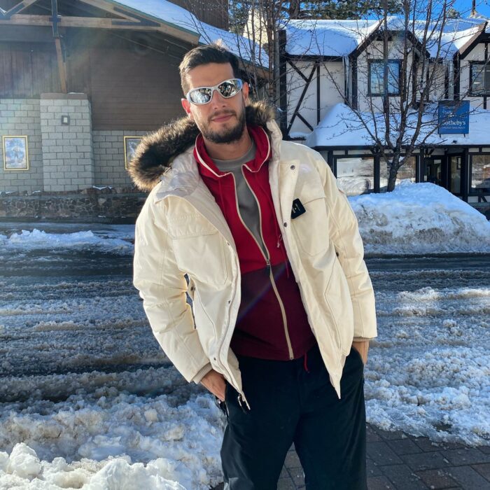 Adrián Marcelo con chamarra blanca y lentes en lugar nevado