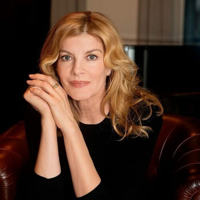 Rene Russo con cabello rubio y blusa negra 